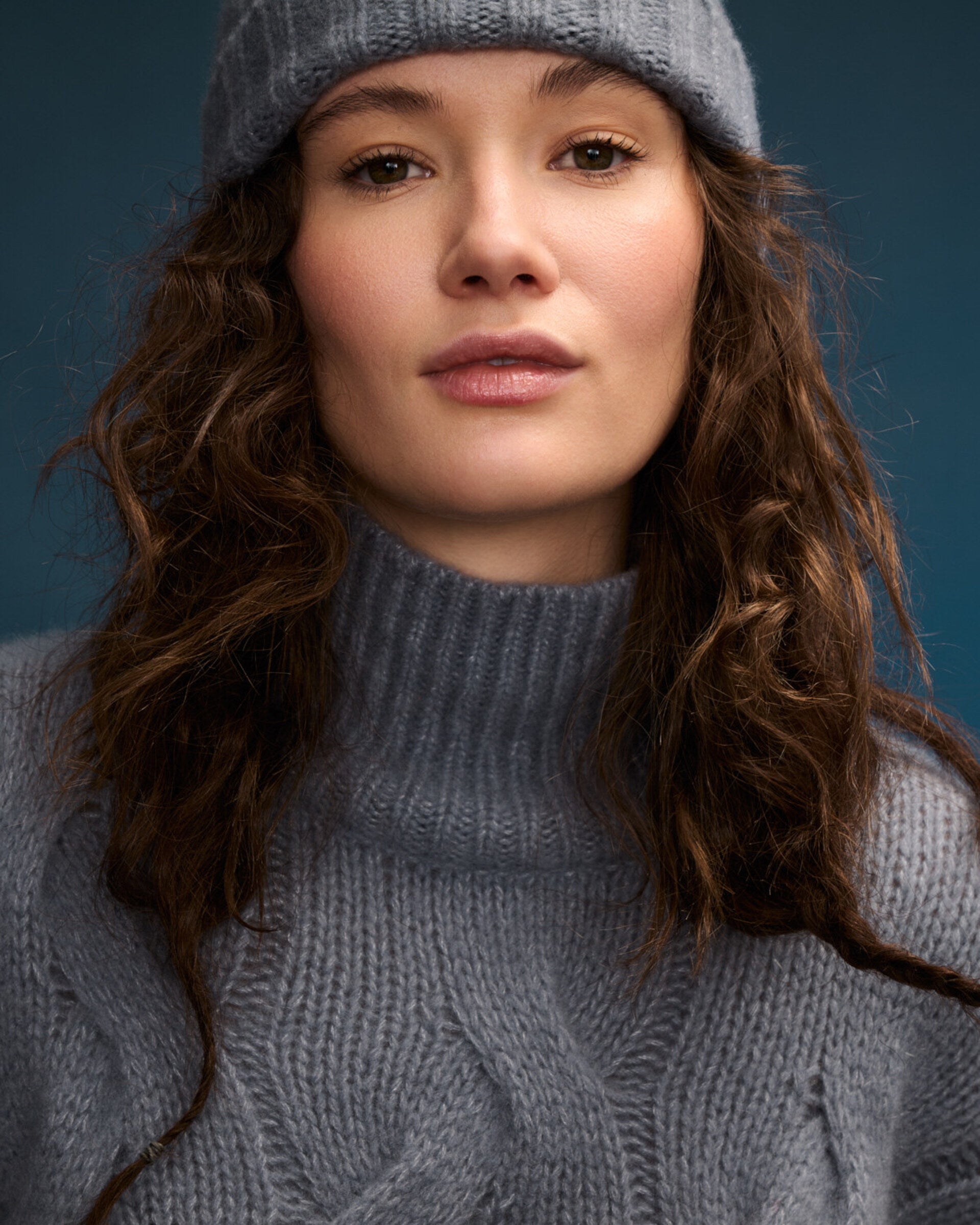 Damen Pullover aus 75 % Kaschmir und 25 % Seide in Blue Mirage – grob gestrickter Pullover mit Zopfstrickmuster in oversized Passform mit langer, weiter Silhouette. Das Modell verfügt über einen hohen Stehkragen in Rippstruktur, eine überschnittene Schulter sowie lange, weite Ärmel. Ärmelbündchen und Saum sind in Rippstruktur gearbeitet und unterstreichen den markanten Strickcharakter des Designs.
