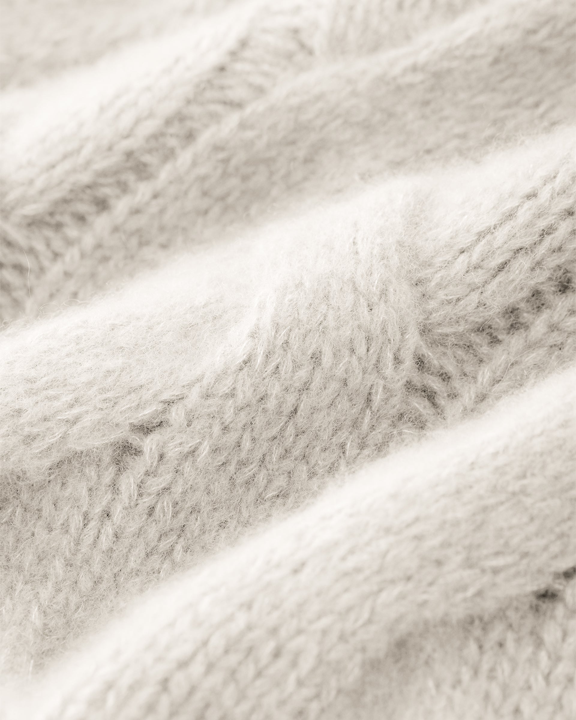 Damen Pullover aus 75 % Kaschmir und 25 % Seide in Ivory – grob gestrickter Pullover mit Zopfstrickmuster in oversized Passform mit langer, weiter Silhouette. Das Modell verfügt über einen hohen Stehkragen in Rippstruktur, eine überschnittene Schulter sowie lange, weite Ärmel. Ärmelbündchen und Saum sind in Rippstruktur gearbeitet und unterstreichen den markanten Strickcharakter des Designs.