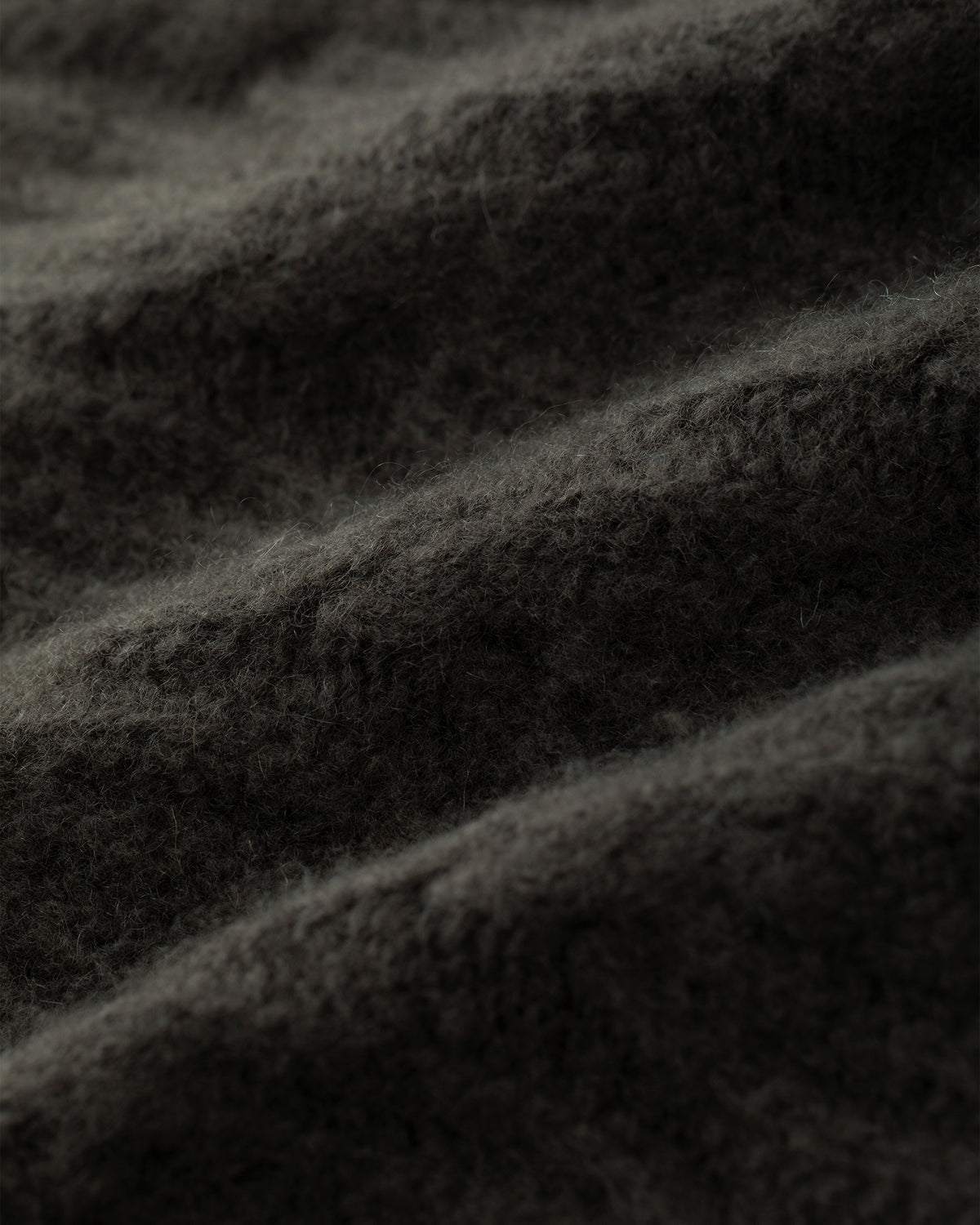 Damen Cardigan aus 75 % Kaschmir und 25 % Seide in Black Forest – Cardigan mit Zopfstrickmuster in mittelschwerer Qualität und oversized Passform mit langer, weiter Silhouette. Das Modell verfügt über eine Knopfleiste mit Knöpfen aus waschbarem Leder, eine überschnittene Schulter sowie lange, relaxte Ärmel. Ärmelbündchen und Saum sind in Rippstruktur gearbeitet und verleihen dem Design einen markanten, zeitlosen Look.
