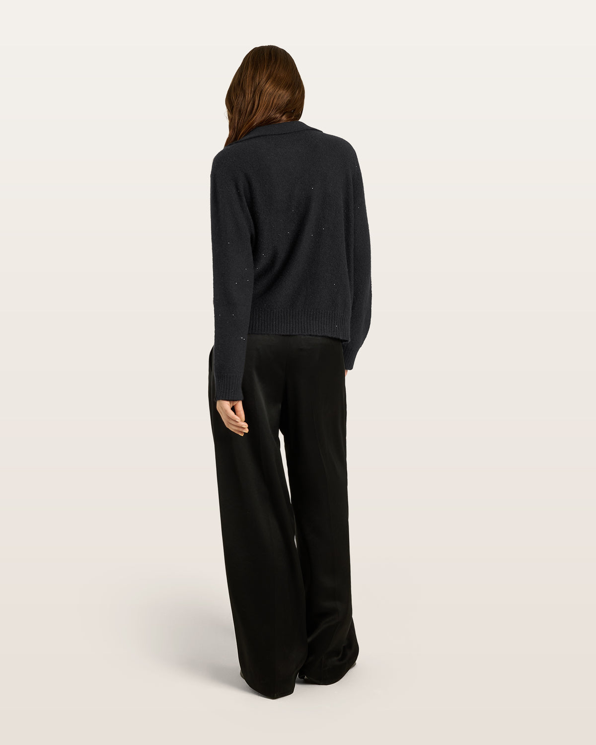 Damen Pullover aus 60 % Kaschmir, 39 % Seide und 1 % Pailletten in Black – links gestrickter Pullover in mittelschwerer Qualität mit lockerer Passform, Polokragen mit tiefer, offener Leiste, klassischer, leicht überschnittener Schulterform sowie langen, relaxten Ärmeln. Ärmelbündchen und Saum sind in Rippstruktur gearbeitet. Dezent eingearbeitete Pailletten verleihen dem Modell einen eleganten, schimmernden Akzent.