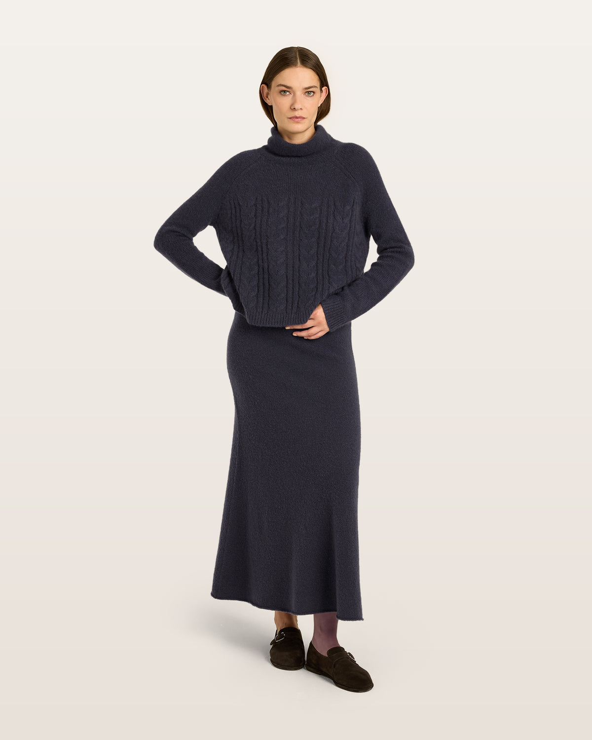 Damen Pullover aus 75 % Kaschmir und 25 % Seide in Graphite Grey – glatt gestrickter Pullover mit Zopfstrickmuster in mittelschwerer Qualität und figurbetonter Passform. Das Modell verfügt über einen Kragen, der als Stehkragen oder Rollkragen getragen werden kann, Raglanärmel sowie lange, schmale Ärmel. Ärmelbündchen und Saum sind in Rippstruktur gearbeitet und verleihen dem Design einen stilvollen Abschluss.