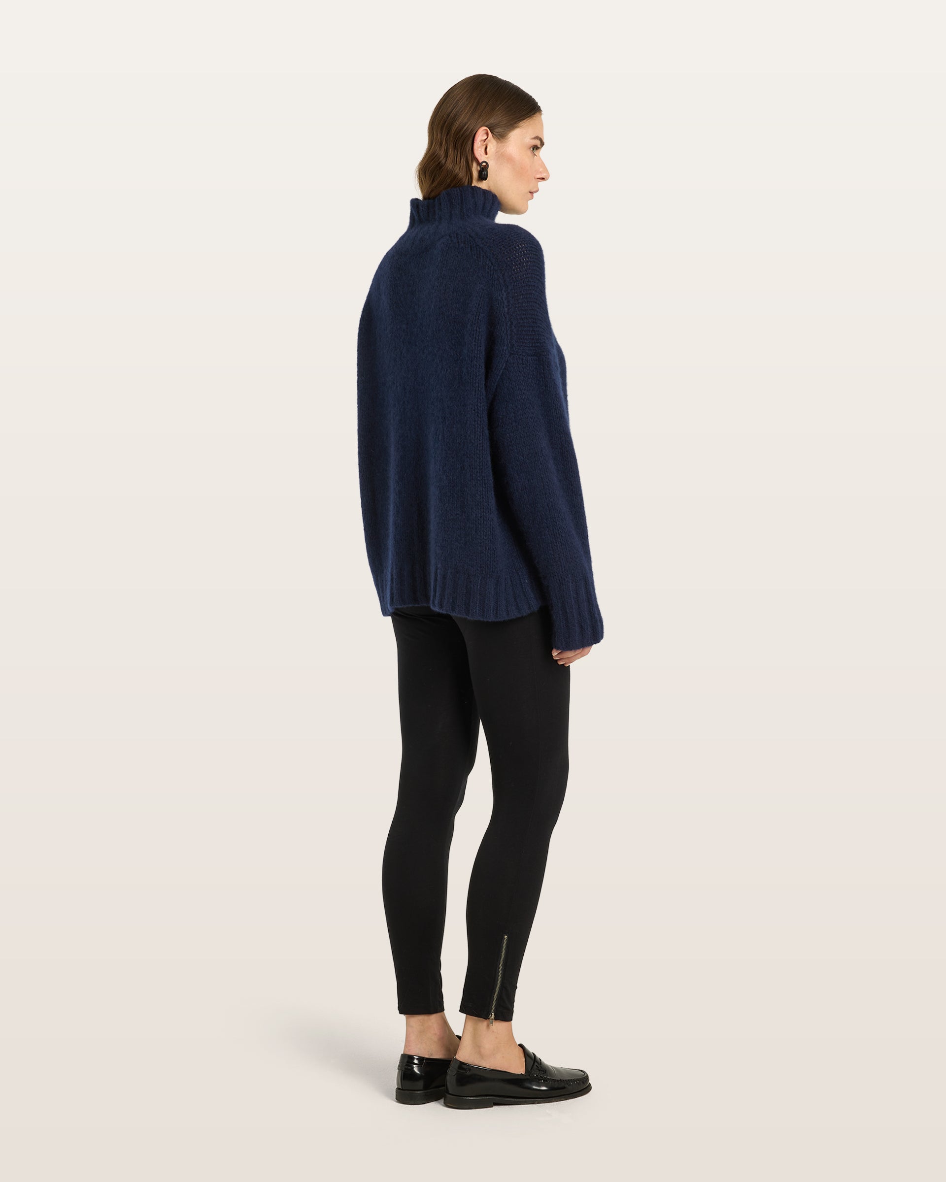 Damen Pullover aus 75 % Kaschmir und 25 % Seide in French Navy – glatt gestrickter Pullover in grober Strickqualität mit oversized Passform in langer, weiter Silhouette, hohem Stehkragen in Rippstruktur, überschnittener Schulter mit nach hinten verlegter Schulternaht sowie langen, weiten Ärmeln. Ärmelbündchen und Saum sind in Rippstruktur gearbeitet und verleihen dem Modell einen modernen, markanten Look.
