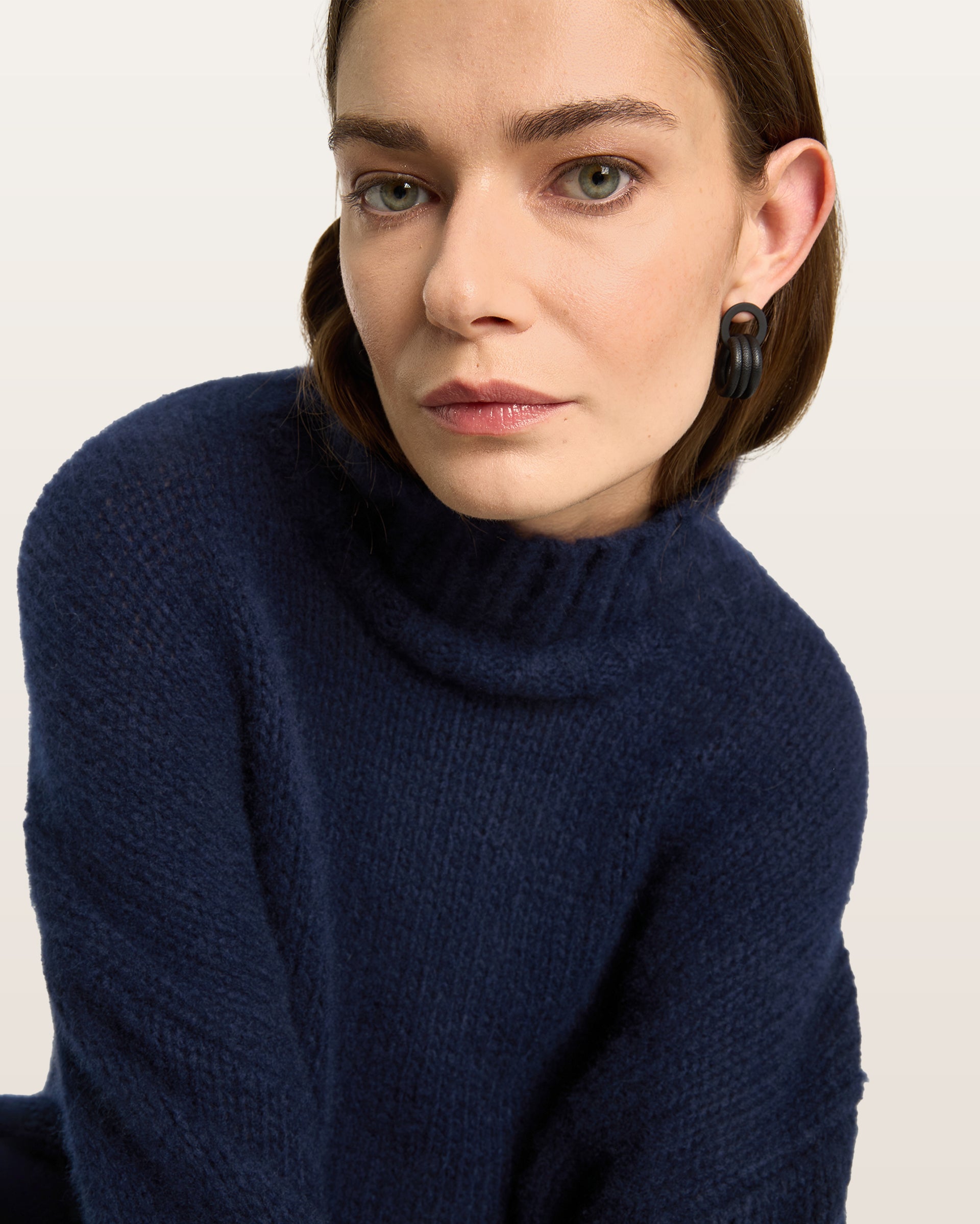Damen Pullover aus 75 % Kaschmir und 25 % Seide in French Navy – glatt gestrickter Pullover in grober Strickqualität mit oversized Passform in langer, weiter Silhouette, hohem Stehkragen in Rippstruktur, überschnittener Schulter mit nach hinten verlegter Schulternaht sowie langen, weiten Ärmeln. Ärmelbündchen und Saum sind in Rippstruktur gearbeitet und verleihen dem Modell einen modernen, markanten Look.
