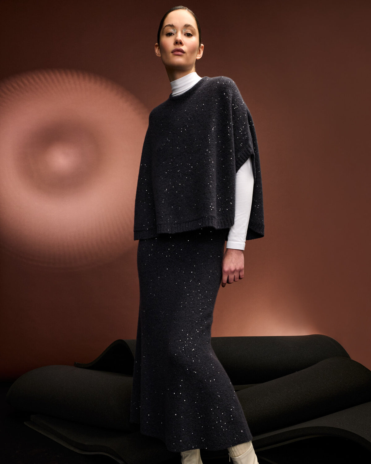 Damen Strickrock aus 56 % Kaschmir, 28 % Baumwolle, 12 % Polyamid, 2 % Elastan und 2 % Pailletten in Graphite Grey – links gestrickter Rock in mittelschwerer Qualität mit figurbetonter A-Linie und Midi-Länge. Das Modell verfügt über einen Taillenbund mit Gummizug. Dezent eingearbeitete Pailletten verleihen dem Rock einen eleganten, schimmernden Akzent.
