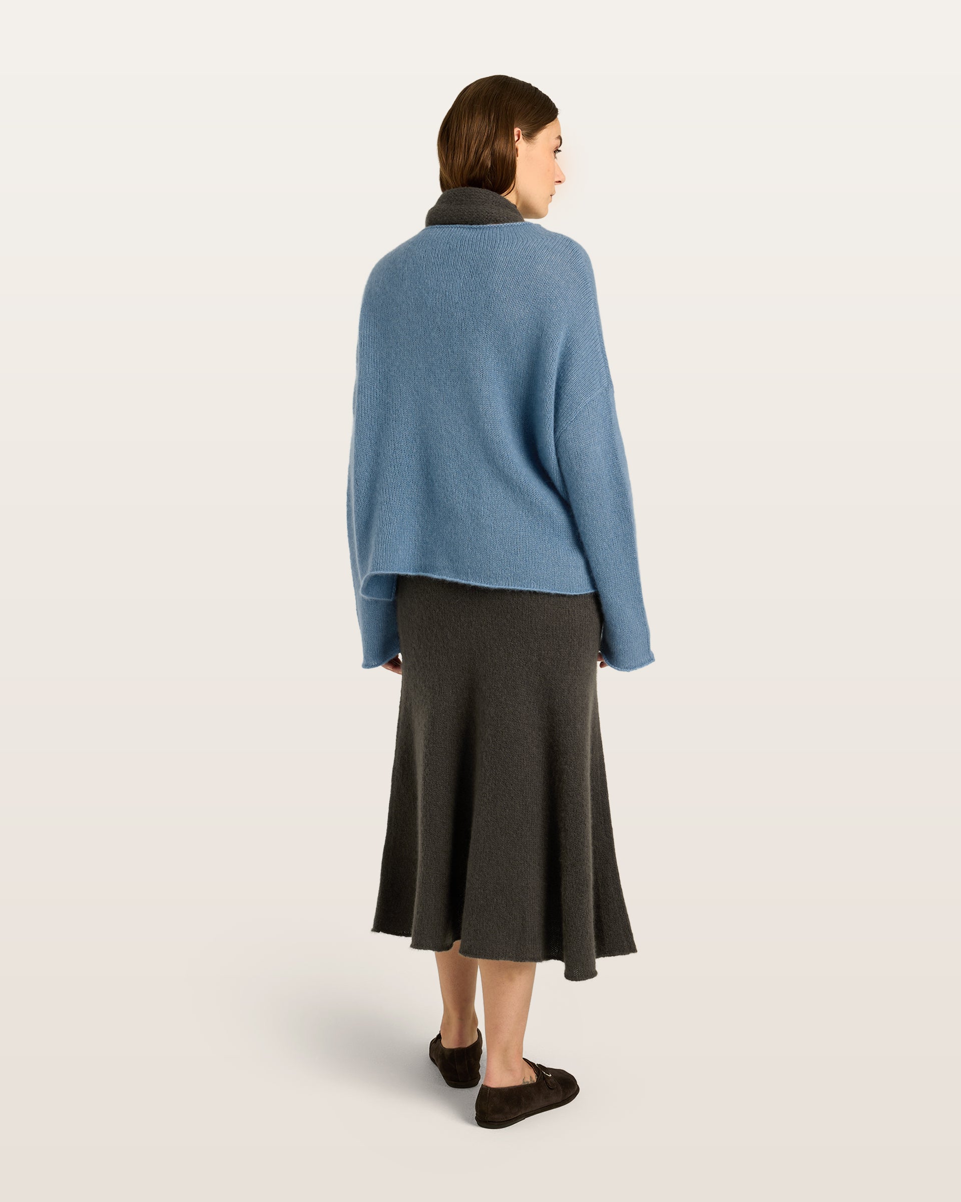 Damen Pullover aus 75 % Kaschmir und 25 % Seide in Blue Fog – glatt und locker gestrickter Pullover in mittelschwerer Qualität mit oversized Passform, breiter und kurzer Silhouette sowie cleanem Rundhalsausschnitt. Überschnittene Schultern und lange, relaxte Ärmel unterstreichen den modernen Look, während Ärmelbündchen und Saum mit speziellem Finish für einen besonderen Akzent sorgen.