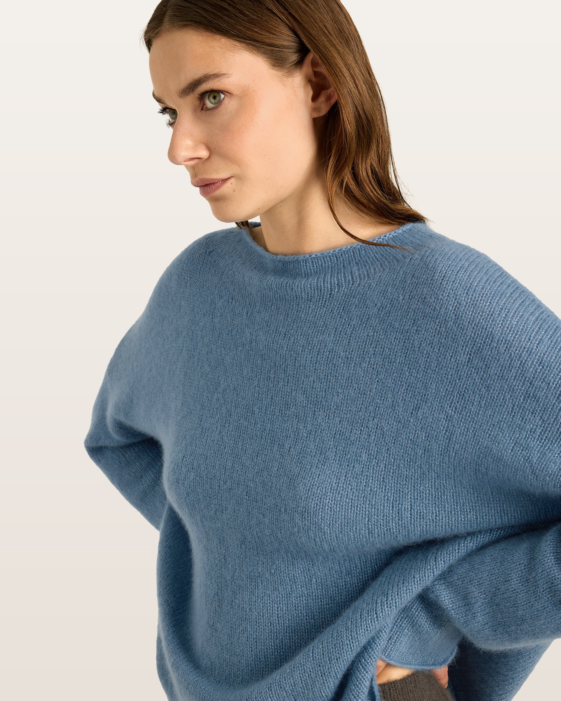 Damen Pullover aus 75 % Kaschmir und 25 % Seide in Blue Fog – glatt und locker gestrickter Pullover in mittelschwerer Qualität mit oversized Passform, breiter und kurzer Silhouette sowie cleanem Rundhalsausschnitt. Überschnittene Schultern und lange, relaxte Ärmel unterstreichen den modernen Look, während Ärmelbündchen und Saum mit speziellem Finish für einen besonderen Akzent sorgen.