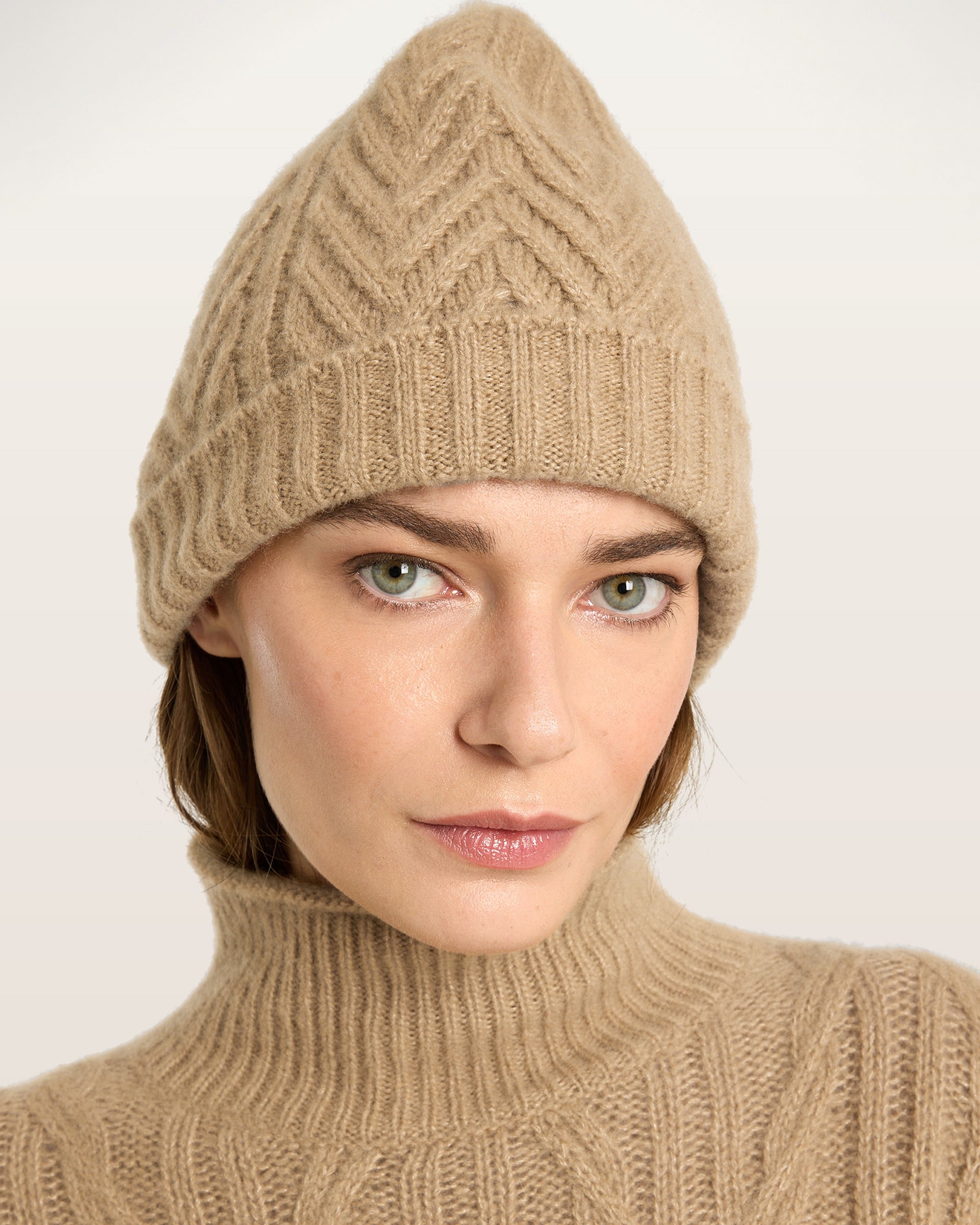 Damen Mütze aus 75 % Kaschmir und 25 % Seide in Warm Sand – Mütze mit Zopfmuster in mittelschwerer Strickqualität. Der Saum in Rippstruktur sorgt für einen klassischen Abschluss und einen angenehmen Sitz.
