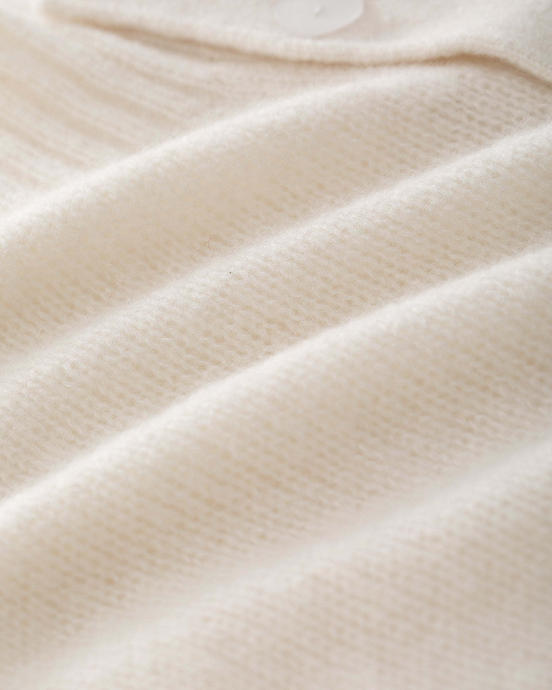 Damen Kurzarm-Jacket aus 75 % Kaschmir und 25 % Seide in ivory (cremeweiß) – mittelschwerer, glatt gestrickter Style in körperbetonter Passform mit Knopfleiste aus Kunststoff, klassischer Schulter, leichten Puff-Halbärmeln sowie Rippbündchen und hohem Ripp-Saum