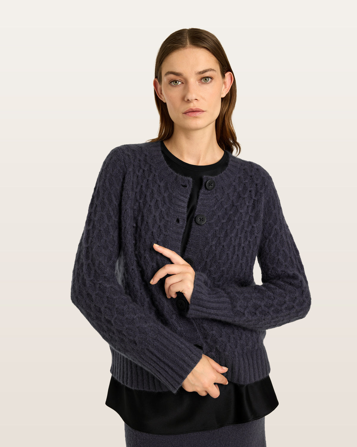 Damen Cardigan aus 75 % Kaschmir und 25 % Seide in Graphite Grey – Cardigan mit grafischem Zopfstrickmuster in mittelschwerer Qualität mit körperbetonter, gerader Passform, Rundhalsausschnitt mit Kragen in Rippstruktur sowie klassischer Schulterform und langen, schmalen Ärmeln. Ärmelbündchen und Saum sind in Rippstruktur gearbeitet. Eine gerippte Knopfleiste mit Knöpfen aus waschbarem Leder rundet das Design stilvoll ab.