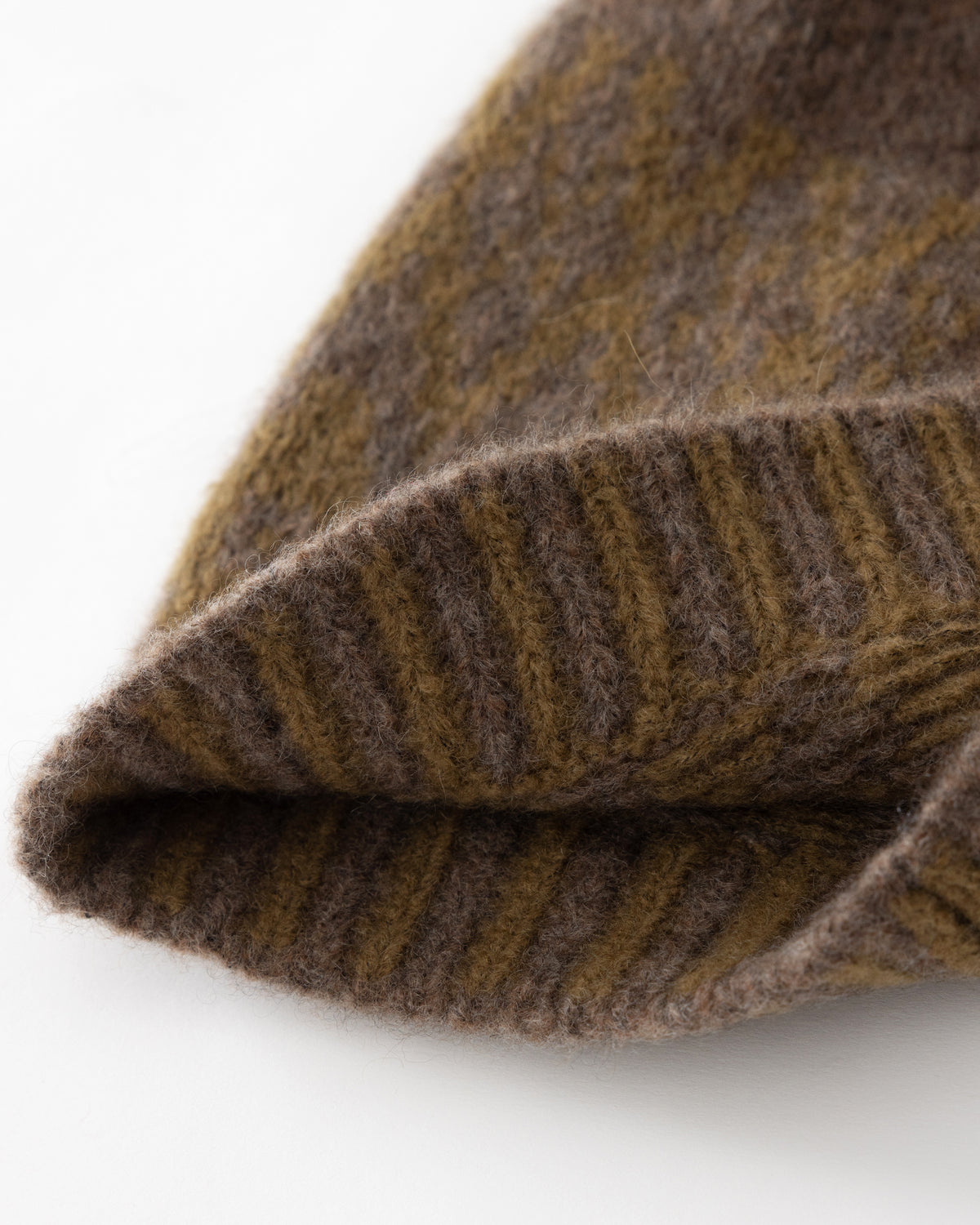 Mütze aus 75% Kaschmir, 25% Seide in Wilderness Tapenade – Zweifarbig gestrickte Mütze mit geometrischem Jacquardmuster, geripptem Umschlag mit vertikaler Struktur und abgerundeter Form.