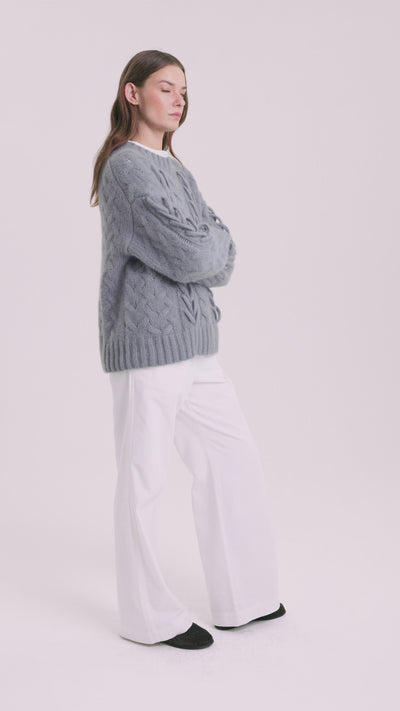 Damen Pullover aus 75 % Kaschmir und 25 % Seide in Blue Mirage – Pullover mit Zopfstrickmuster und zusätzlich applizierten 3D-Zöpfen in grober Strickqualität mit relaxter Passform, Rundhalsausschnitt mit Kragen in Rippstruktur, überschnittener Schulter sowie langen, relaxten Ärmeln. Ärmelbündchen und Saum sind in Rippstruktur gearbeitet und unterstreichen den markanten, handwerklichen Charakter des Designs.
